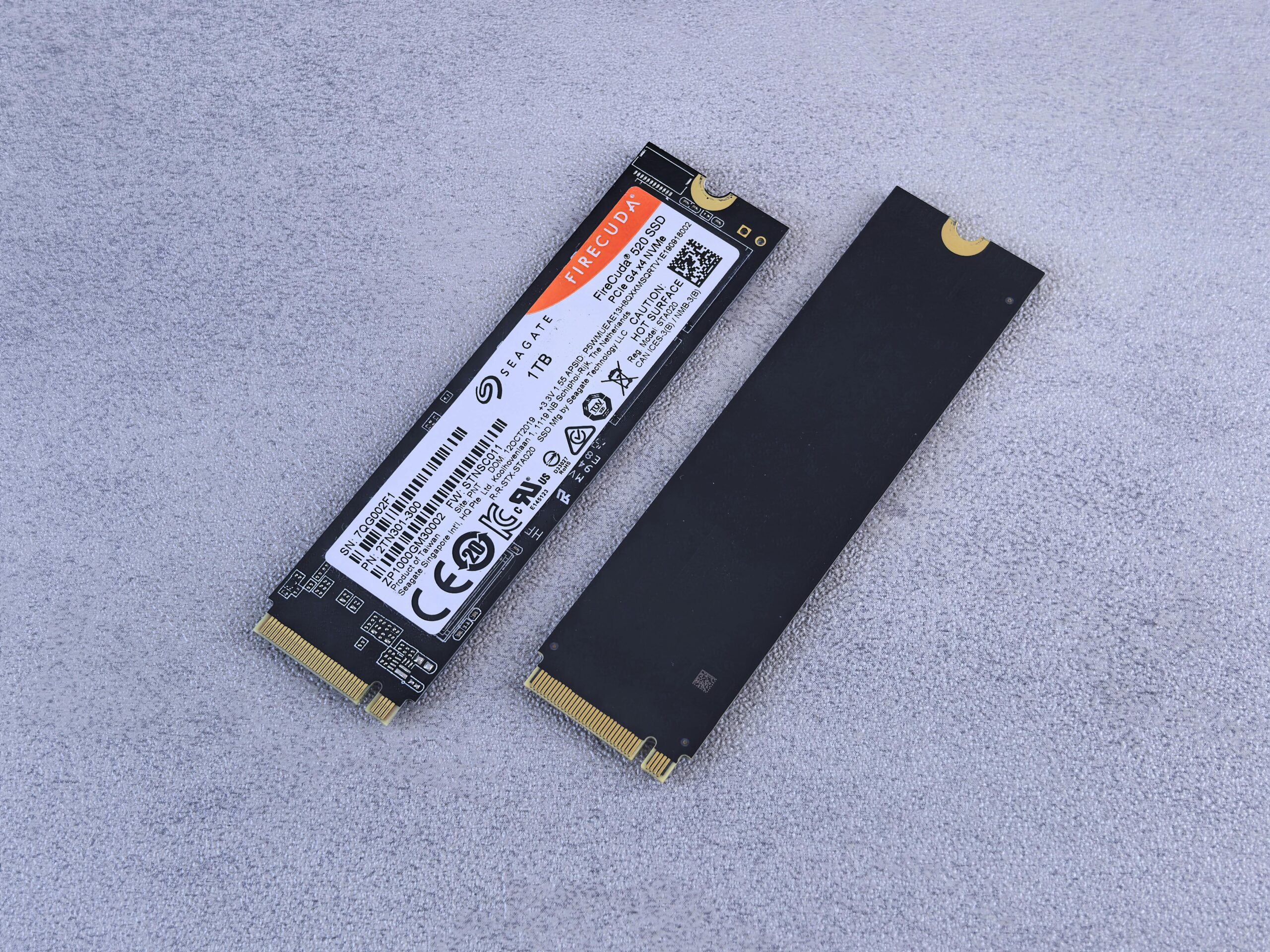 Two NVMe SSDs, Seagate FireCuda, on a gray background for tech enthusiasts.
